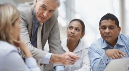 Senior business man discussing project on laptop with staff